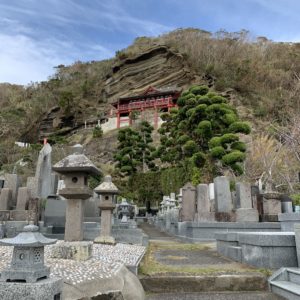 並ぶお墓の向こうの崖に建つ大福寺