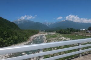 高瀬川の彼方に雪渓交じりの北アルプスを眺める