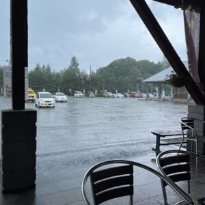 雨の松尾八幡平ビジターセンターの軒先の内側から雨の風景を眺める